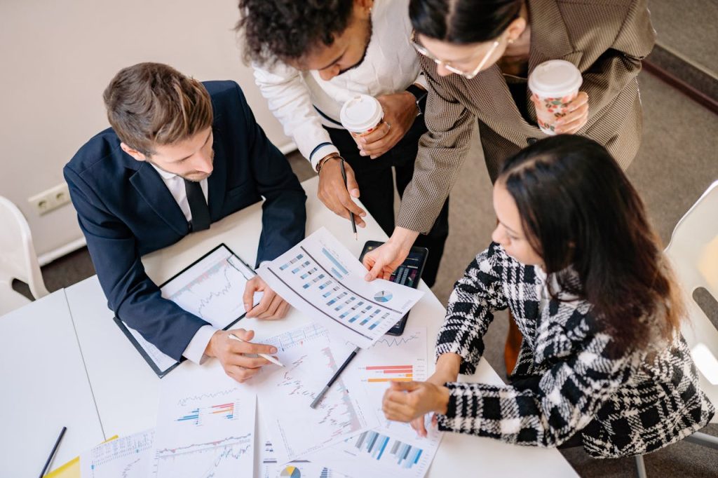 Crafting Captivating Headlines: Your awesome post title goes here A diverse team in business attire collaborates over graphs and charts for a successful project.